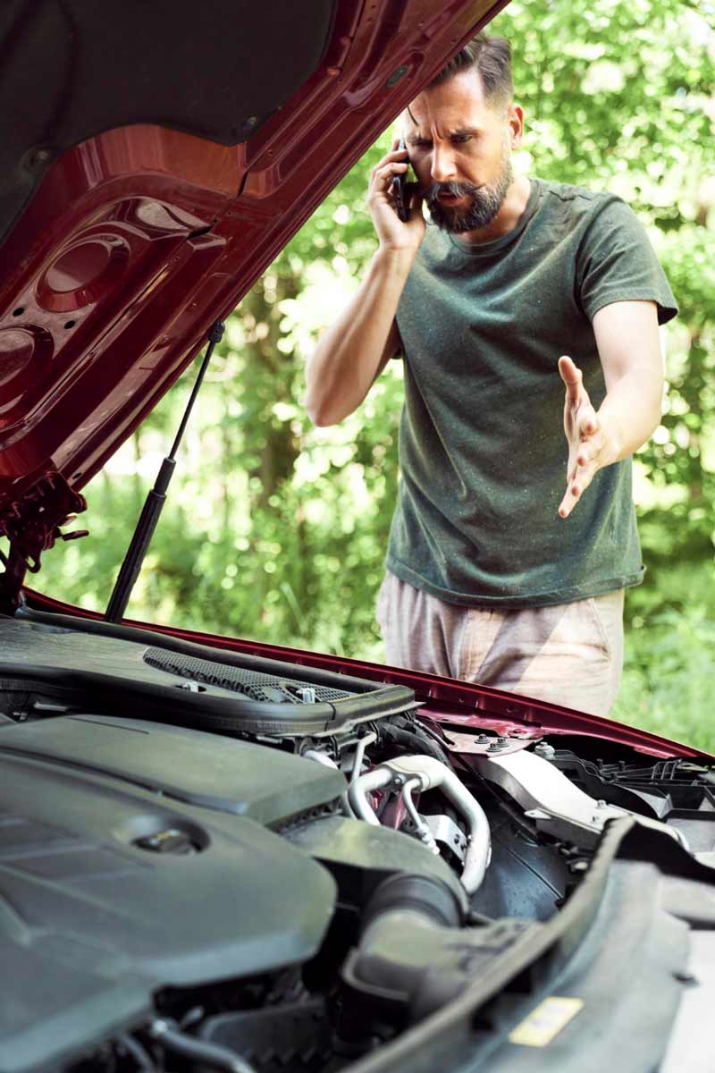 Junger Mann prüft Getriebeschaden bei Schrottauto Ankauf Gütersloh